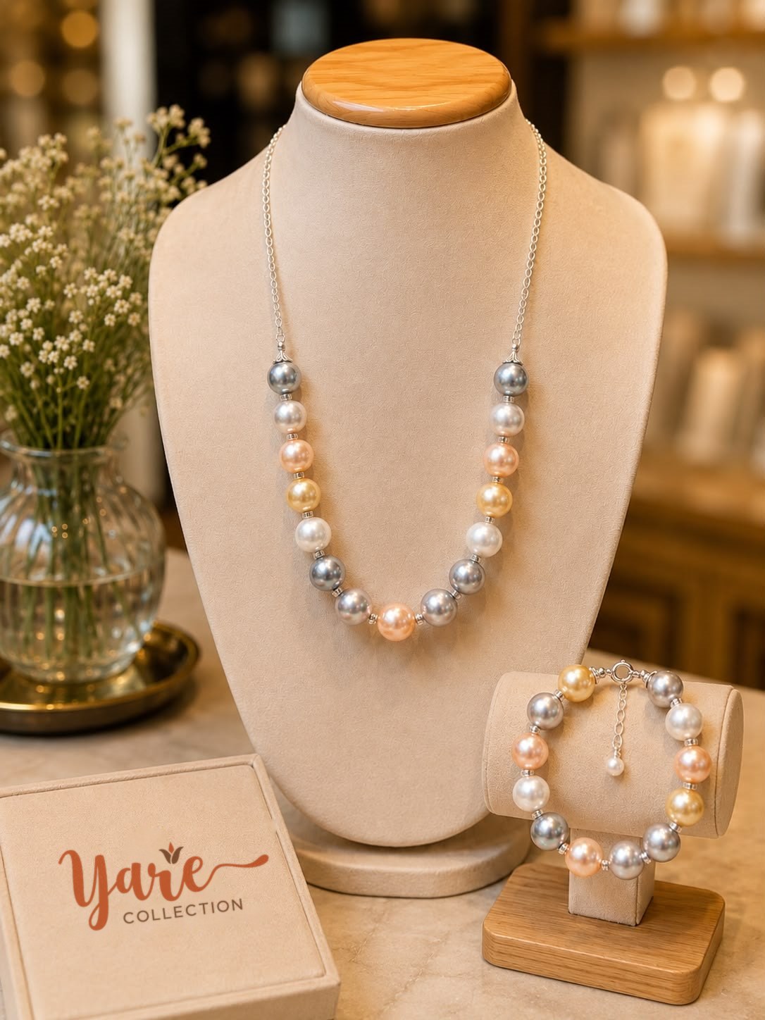 A pearl necklace and bracelet set beside a Yare Collection box
