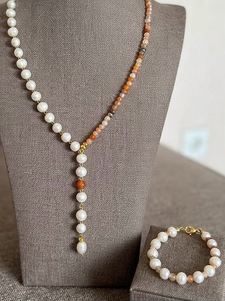 A pearl and agate Y-necklace on a linen bust with its matching bracelet