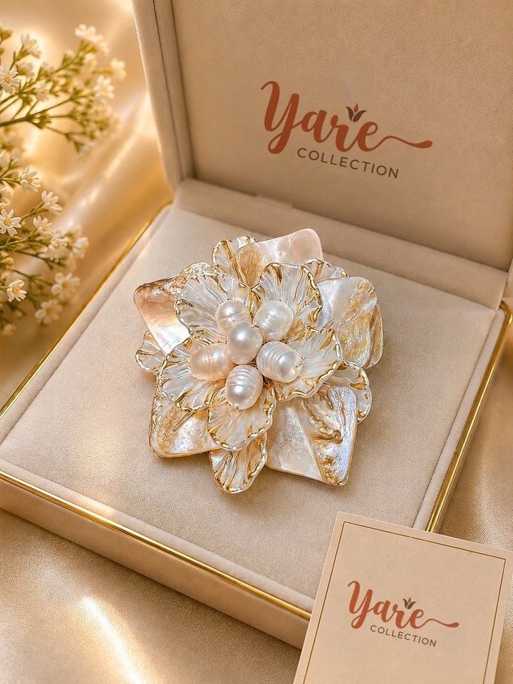 A pearl shell flower brooch in its Yare Collection gift box